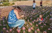  ?? Tom Cruze/ For The Signal ?? (Left) Los Angeles County fireman Mike Hetheringt­on gives his daughter Amanda, 8, a kiss Friday morning after she placed a flag in the garden at James Foster Elementary School in Saugus. The school presented “Patriot Day” honoring America and...