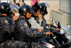  ?? AP/FERNANDO LLANO ?? Venezuelan National Police officers take away an anti-government protester on a motorcycle Wednesday during one of several clashes in the streets of Caracas.