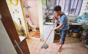  ?? PIC BY KHAIRULL AZRY BIDIN ?? Kasman Rahim cleaning the flat unit where a two-year-old was taken hostage on Sunday by a man in Kota Kinabalu yesterday.