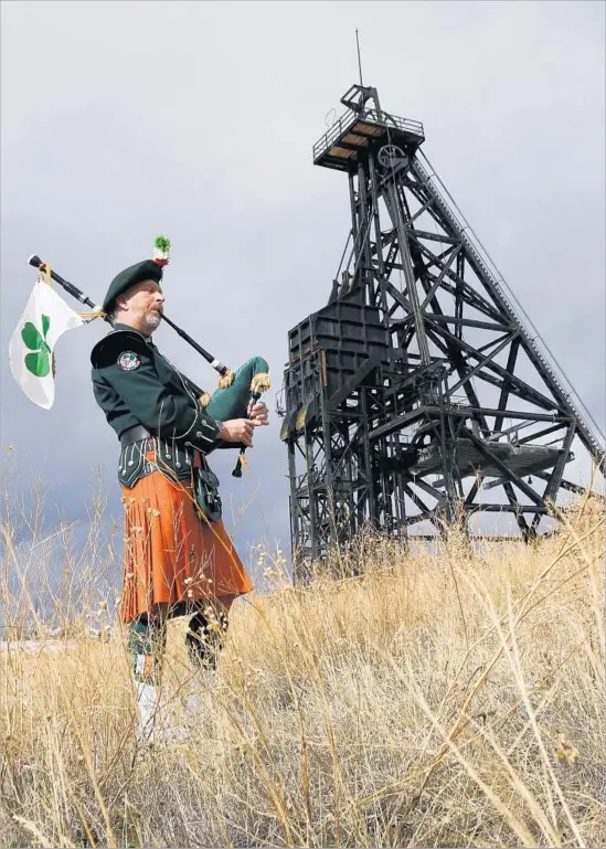  ?? Mark Boster Los Angeles Times ?? ROB SECCOMB, pipe major with the Anaconda AOH Pipes and Drum Corp, plays near a head frame in Butte. Like many here, he’s descended from Irish immigrants.