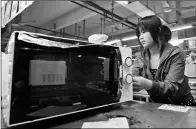  ?? CHEN YEHUA / XINHUA ?? A Galanz employee works on a microwave oven assembly line in Foshan, Guangdong province.