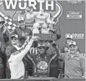  ?? JASON MINTO/AP ?? Martin Truex Jr. hoists the trophy after winning the rain-delayed NASCAR 400 on Monday at Dover Motor Speedway in Dover, Del.