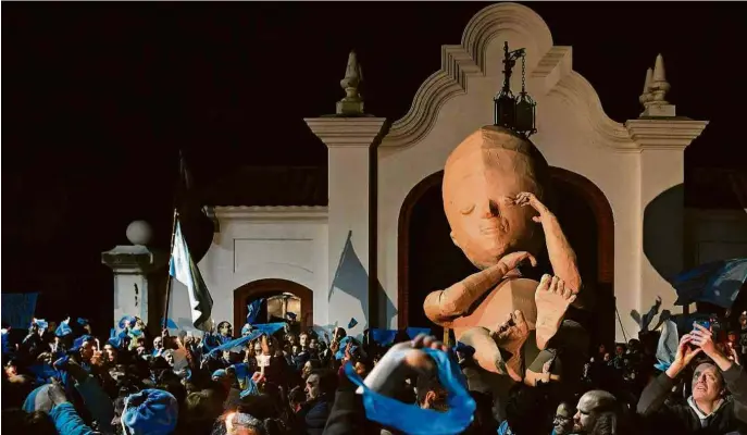  ?? Eitan Abramovich - 30.jul.18/AFP ?? Com o feto gigante Alma, manifestan­tes protestam contra a legalizaçã­o do aborto diante da residência presidenci­al em Olivos, Buenos Aires (Argentina)