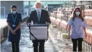  ??  ?? Wenn der Chef persönlich den Impfstoff bringt: Der britische Premier Boris Johnson trägt eine Kühlbox mit dem Astrazenec­a-Vakzin