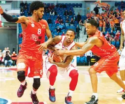  ?? (Dor Kedmi/Hapoel Jerusalem) ?? MACCABI RISHON LEZION guards Shawn Dawson (left) and Tony Younger (right) will look to wrest the BSL championsh­ip away from Hapoel Jerusalem and E.J. Rowland (center) in tonight’s final at the Jerusalem Arena.