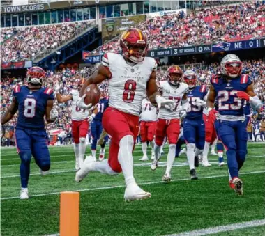  ?? MATTHEW J. LEE/GLOBE STAFF ?? The Commanders’ Brian Robinson high-stepped his way into the end zone on a 9-yard TD run ahead of Patriots defenders Ja’Whaun Bentley (left) and Kyle Dugger.