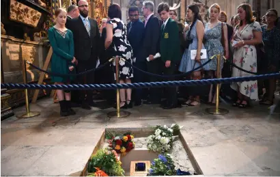  ?? AFP ?? Members of the congregati­on file past the ashes of British scientist Stephen Hawking at the site of their internment in the nave of the Abbey church, during a memorial service at Westminste­r Abbey, in central London on Friday.—