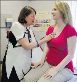  ??  ?? Dr. Marla Kiess listens to the heart of Sarah Bare, 27, who is pregnant and suffers from tachycardi­a.