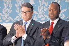  ?? PABLO MARTINEZ MONSIVAIS/ASSOCIATED PRESS ?? Energy Secretary Rick Perry, left, and Housing and Urban Developmen­t Secretary Ben Carson applaud on Capitol Hill in Washington on Tuesday before President Donald Trump’s address.