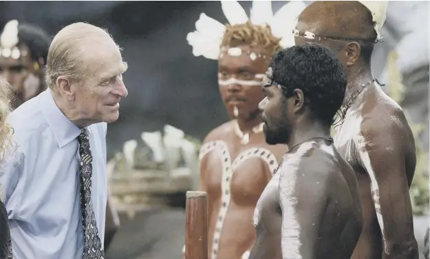  ??  ?? The Duke of Edinburgh talking to Aboriginal performers after watching a culture show at Tjapukai Aboriginal Culture Park, Cairns, Queensland, Australia