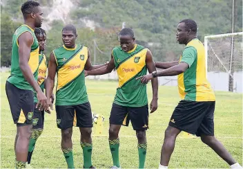  ?? FILE ?? Coach Theodore Whitmore (right) gives instructio­ns to several members of the national senior football team during a training session last year.