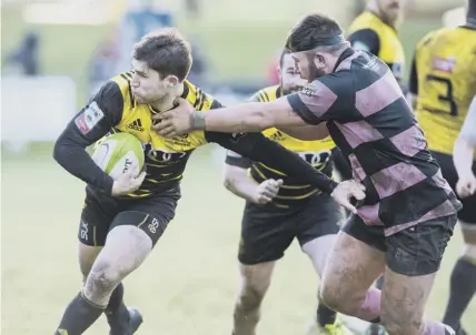  ??  ?? 2 Melrose stand-off Jason Baggot, left, tries to shake off a tackle during the Borderers’ defeat by Ayr at The Greenyards on Saturday.