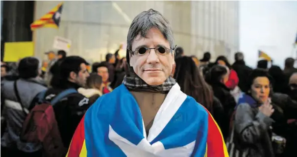  ?? BILD: SN/AP ?? In Katalonien halten die Proteste gegen die Festnahme von Carles Puigdemont an. Viele Demonstran­ten tragen Masken mit seinem Gesicht. In der Nacht auf Montag hat es in Barcelona Ausschreit­ungen mit zahlreiche­n Verletzten gegeben.