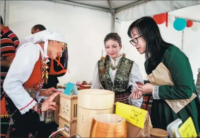  ?? DIMITAR DILKOFF / AGENCE FRANCE-PRESSE ?? A Chinese tourist attends the third Chinese-Bulgarian yogurt festival in the village of Momchilovt­si on Sept 8. The event attracted hundreds of Chinese visitors, drawn by their love of “Mosili’an” drinking yogurt.