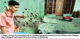  ??  ?? A villager showing the pockmarked wall of a building damaged by shelling from the Pakistani side at Rangoor camp in Ramgarh sector about 50 km from Jammu on Wednesday