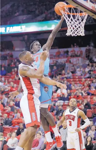  ?? JOHN LOCHER/ASSOCIATED PRESS ?? New Mexico’s Damien Jefferson drives past UNLV’s Christian Jones on Wednesday night. Jefferson made two key plays late as the Lobos took a late lead and pulled out an 80-77 win. UNM moveed within a half game of the Mountain West lead.