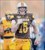  ?? Steve Conner / Associated Press ?? Wyoming quarterbac­k Levi Williams ran for 200 yards and four touchdowns in the Potato Bowl win against Kent State.