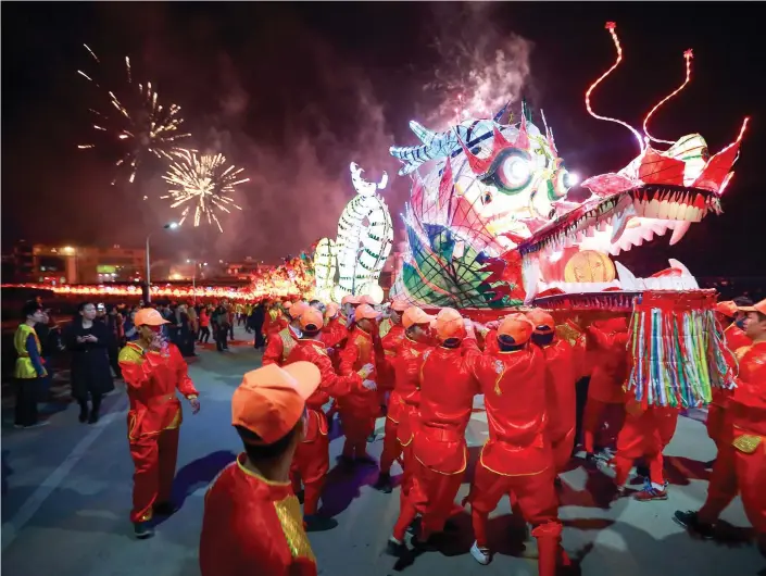  ?? (Reuters) ?? PEOPLE PERFORM with a long dragon lantern as they celebrate the Chinese New Year, in Longyan, Fujian province, last February.