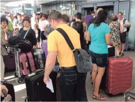  ?? PHOTO: AP ?? Passengers stand outside London’s Heathrow airport after flights were cancelled due to the airport suffering an IT systems failure on Saturday. British Airways cancelled flights from Heathrow and Gatwick, upending the travel plans of tens of thousands...