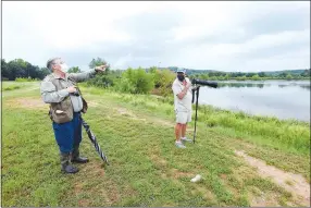  ??  ?? Joe Neal (left) and Terry Stanfill stop during a walk around the pond to view a variety of birds.