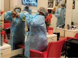  ?? — BIPLAB BANERJEE ?? Workers wearing protective suits sanitises inside a parlour in New Delhi on Sunday.