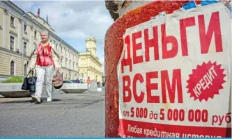  ??  ?? MOSCOW: A woman passes a notice advertisin­g loans in downtown Moscow. — AFP