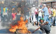  ?? /Reuters ?? Burning anger: Demonstrat­ors protesting against electoral laws erect a fire barricade in Antananari­vo, Madagascar.