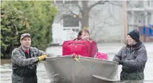  ?? ADRIAN WYLD, CP ?? Lise Veillette rides in a boat with some of her belongings Monday as she is pushed to safety in Gatineau, Que.