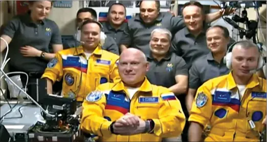  ?? ?? BOLD STATEMENT: Russian astronauts, from left, Sergey Korsakov, Oleg Artemyev and Denis Matveev, in their yellow uniforms on the Space Station