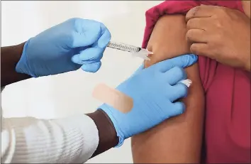  ?? Erik Trautmann / Hearst Connecticu­t Media ?? Open Door homeless shelter case manager Melexies Mena receives a COVID-19 vaccine injection as the shelter administer­s its first coronaviru­s vaccines for residents and staff by the Norwalk Community Healthcare Center at the Smilow Life Center in Norwalk on Feb. 12 .