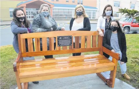  ?? SHARON MONTGOMERY-DUPE • CAPE BRETON POST ?? Teachers at Oceanview Education Centre in Glace Bay including from left, Tina Kennedy-Lohnes, guidance counsellor, Diane McNeil, Rose Abraham, April Parsons, and Grade 8 student Jaime Paige Parsons, reflect by a bench which will be dedicated to the late Leigh-Anne Cox, a former student at the school, during a ceremony at the school today. Leigh-Anne, who died in June after a courageous battle with cancer, inspired so many people at the school the teachers formed a Bee Kind committee and built a little park to carry on the kindness and compassion for others she was noted for.