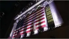  ?? PETER MORGAN — THE ASSOCIATED PRESS ?? An American flag hangs on the front of the New York Stock Exchange.