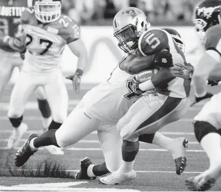  ?? Richar Wolowicz/afp/getty Images ?? Noel Devine of the Montreal Alouettes is stopped by the Calgary Stampeders’ Cordarro Law during their CFL matchup earlier this month at Percival Molson Stadium. Law is doing his part to fill the role left by the injured Charleston Hughes.