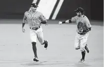  ?? Harry How, Associated Press ?? Houston’s Carlos Correa, left, and Josh Reddick celebrate after Correa made a catch to end the fifth inning against Tampa Bay on Saturday in San Diego.