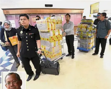  ??  ?? Handle with care: An MACC officer helping to transport evidence to be used in the trial of Otman (inset) at the Sessions Court in Kuala Lumpur.