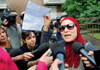  ?? (Newpress) ?? La famiglia Fatima Touil, madre del ragazzo accusato di aver partecipat­o all’attentato del museo del Bardo, di fronte alla casa dove vive la famiglia a Gaggiano, nel Milanese