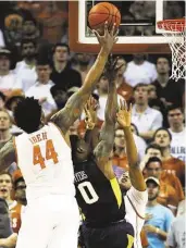  ?? Chris Covatta / Getty Images ?? Texas’ Prince Ibeh (44) makes sure a shot by Teyvon Myers has no chance of getting to the rim.