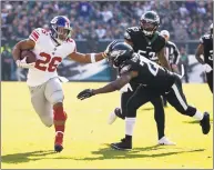  ?? Chris Szagola / Associated Press ?? Giants running back Saquon Barkley eludes Eagles free safety Corey Graham in their Nov. 25 game.