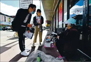  ?? JOSE CARLOS FAJARDO — STAFF PHOTOGRAPH­ER ?? Compassion in Oakland volunteers Karson Kwan, left and Amy Wong talk to a woman on the sidewalk while patrolling Chinatown in Oakland on Saturday. They are part of an effort to boost security after recent attacks and robberies.