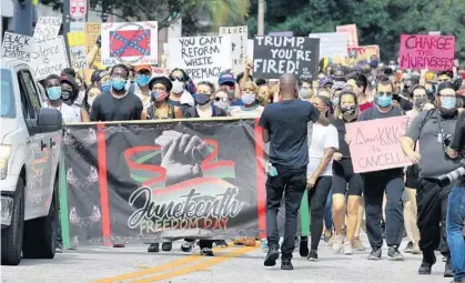  ?? JOE BURBANK/ORLANDO SENTINEL ?? Demonstrat­ors march on Livingston Street from Lake Eola Park in downtown Orlando to commemorat­e the Juneteenth holiday on Friday. Juneteenth celebrates the emancipati­on of slaves in the U.S. and originated in 1865.