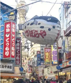  ??  ?? Shinsekai, with its centerpiec­e Tsutenkaku Tower in the background, boasts a colorful history and is now home to numerous restaurant­s specializi­ng in kushi-katsu and fugu.