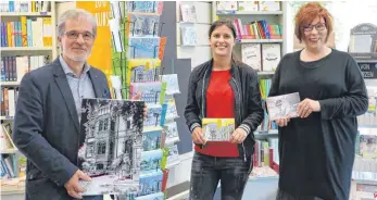  ?? FOTO: FELKER ?? Fotograf Manfred Nester (von links) mit Kim Wursthorn, Betreiberi­n des Cafés „Bella Casa“und Margarete Schmitz von Morys Hofbuchhan­dlung freuen sich, dass es nun Karten mit Trossinger Motiven gibt.