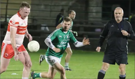  ??  ?? Jim Hughes of Kilanerin under pressure from Peter Travers of Naomh Eanna with referee John Carton in close proximity.