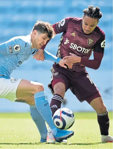  ??  ?? Manchester City’s John Stones puts in a tackle on Helder Costa (Leeds)