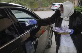  ?? ROGELIO V. SOLIS — THE ASSOCIATED PRESS ?? Usher Gloria Addison hands out a communion packet to a church member in Jackson, Miss.