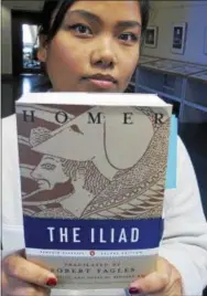  ?? WILSON RING — THE ASSOCIATED PRESS ?? In this photo, University of Vermont student veteran Stephanie Wobby, a medic who served in Iraq and Afghanista­n, holds a copy of “The Iliad,” in Burlington, Vt. In “The Iliad” and “The Odyssey,” Homer wrote in detail familiar to modern soldiers about...