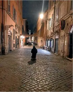  ?? AP ?? A beggar kneels on the pavement of a nearly desert via della Longaretta street in Trastevere area, a street normally crowded in the early evening, especially with tourist, in Rome.