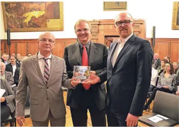  ?? FOTO: ALFONS WINTERSEEL ?? Hermann Kewitz (links), Vorsitzend­er des bürgerscha­ftlichen Vereins proDuisbur­g, überreicht Alexander Kranki (Mitte) den Preis. Oberbürger­meister Sören Link gratuliert.