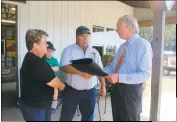  ?? STAFF PHOTOS BY TIFFANY WATSON ?? Maryland Comptrolle­r Peter Franchot, right, presented Shlagel Farms owners, Russell and Eileen Shlagel, with a proclamati­on for 105 years of continuous farming.