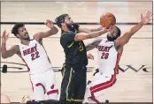 ?? JOHN RAOUX — THE ASSOCIATED PRESS ?? Lakers forward Anthony Davis shoots between Heat forward Jimmy Butler, left, and guard Andre Iguodala during the second half of Game 5of the NBA Finals on Friday in Lake Buena Vista, Fla.